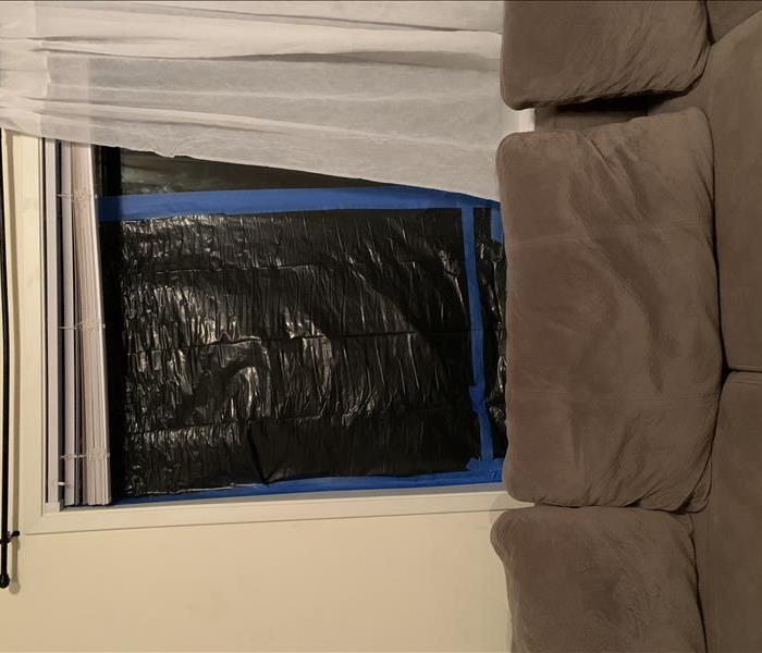 Clean couch and taped up window with garbage bag