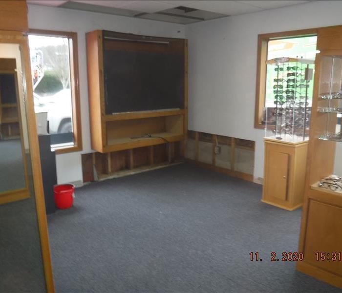 Removed drywall, window, glasses display, red bucket