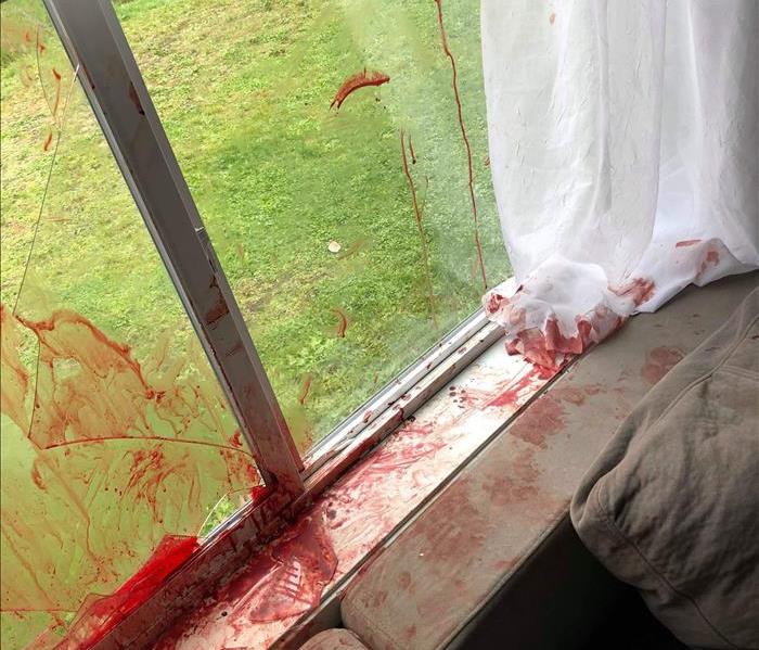 Broken glass window, blood on couch